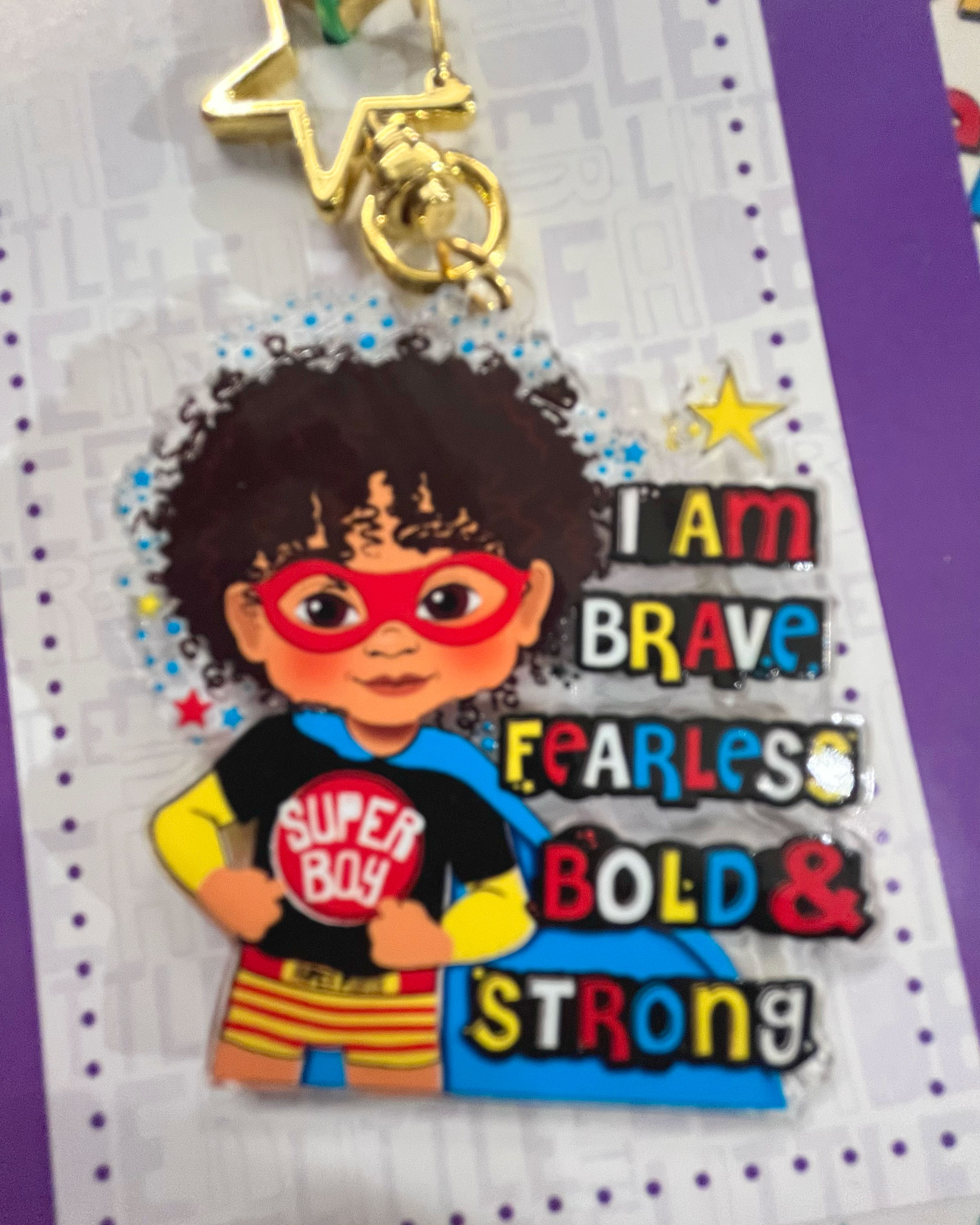 Keychain with brown superhero-themed character on a card