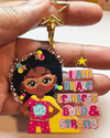 Black girl superhero keyring with afro hair – empowering recycled kids charm. Keychain with black girl character and motivational text on a pink background