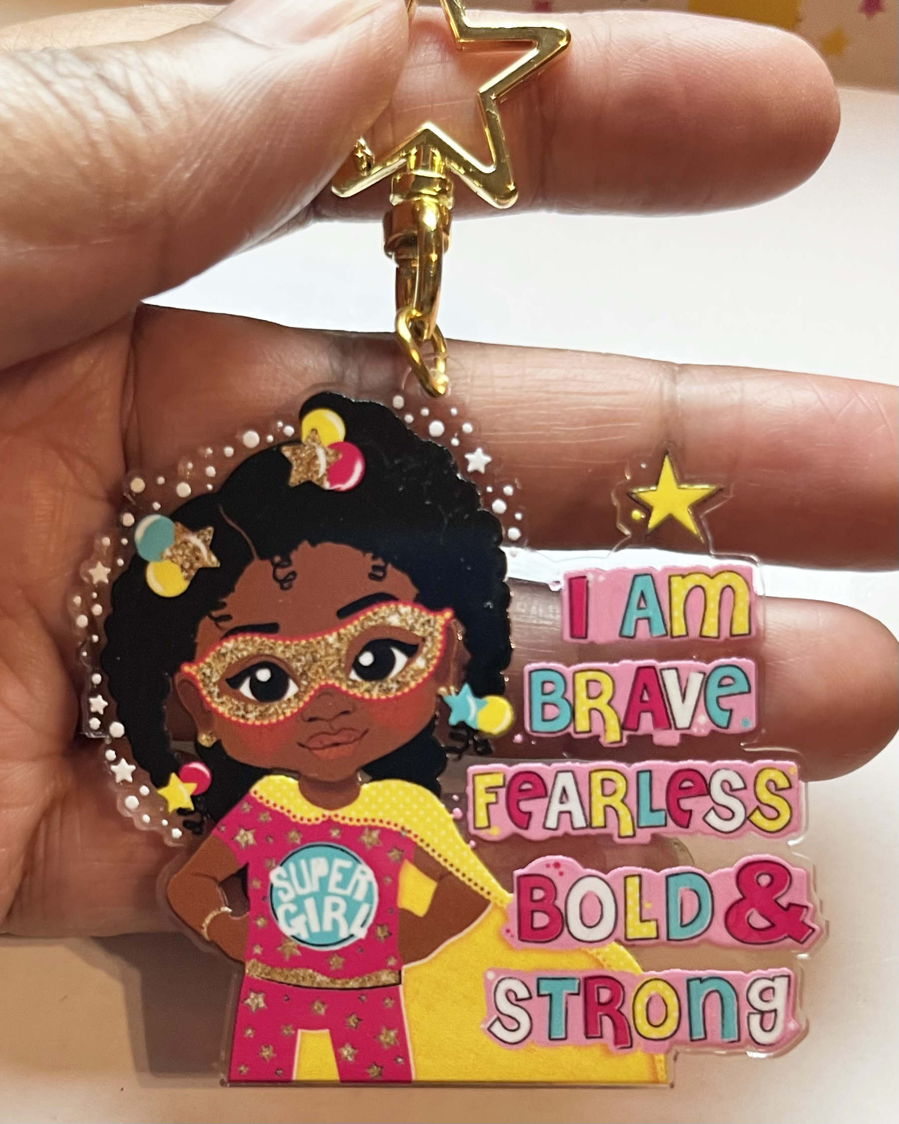 Black girl superhero keyring with afro hair – empowering recycled kids charm. Keychain with black girl character and motivational text on a pink background