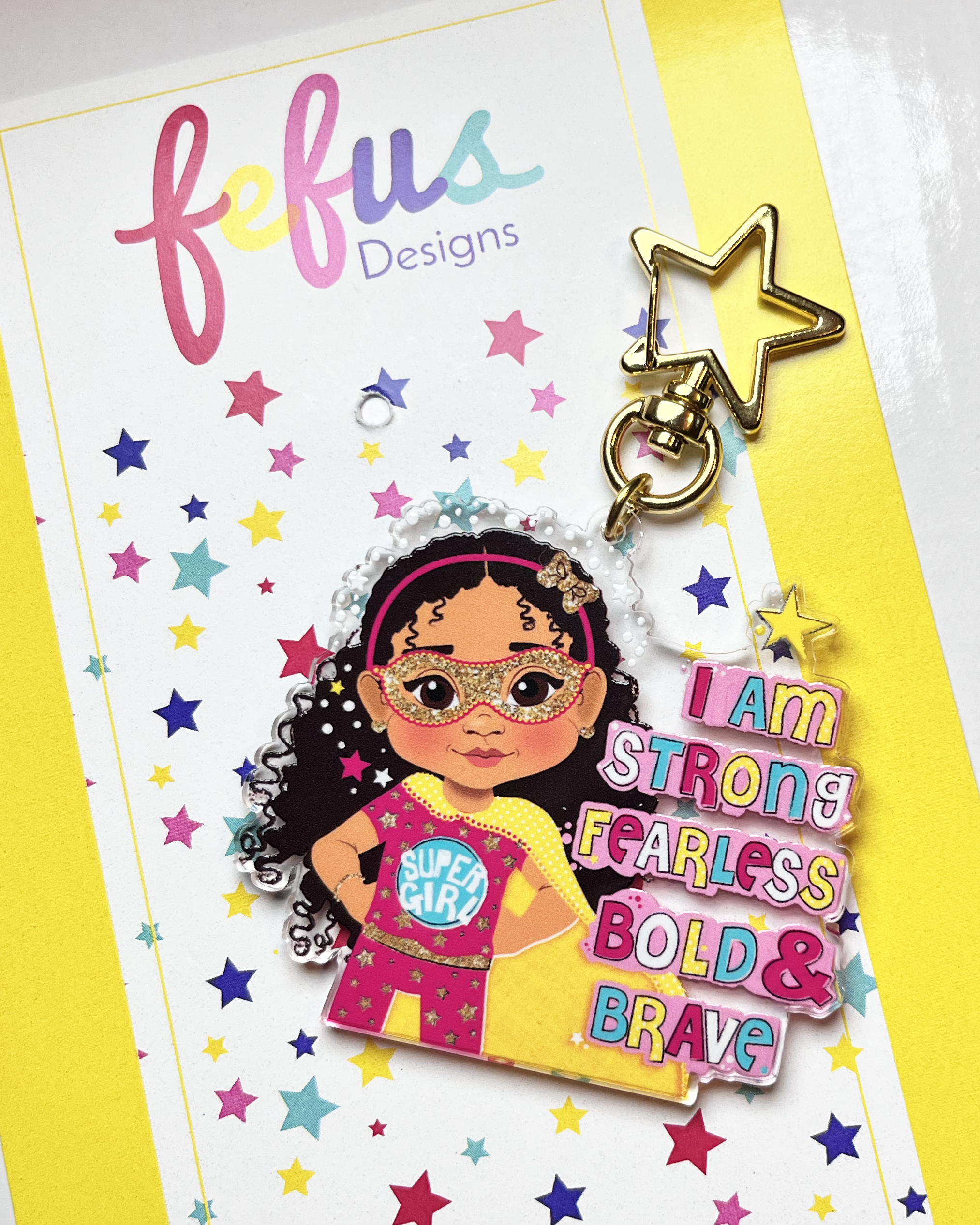 Keychain with a character wearing a mask and text on a colorful star-patterned card with 'fefus Designs' branding.